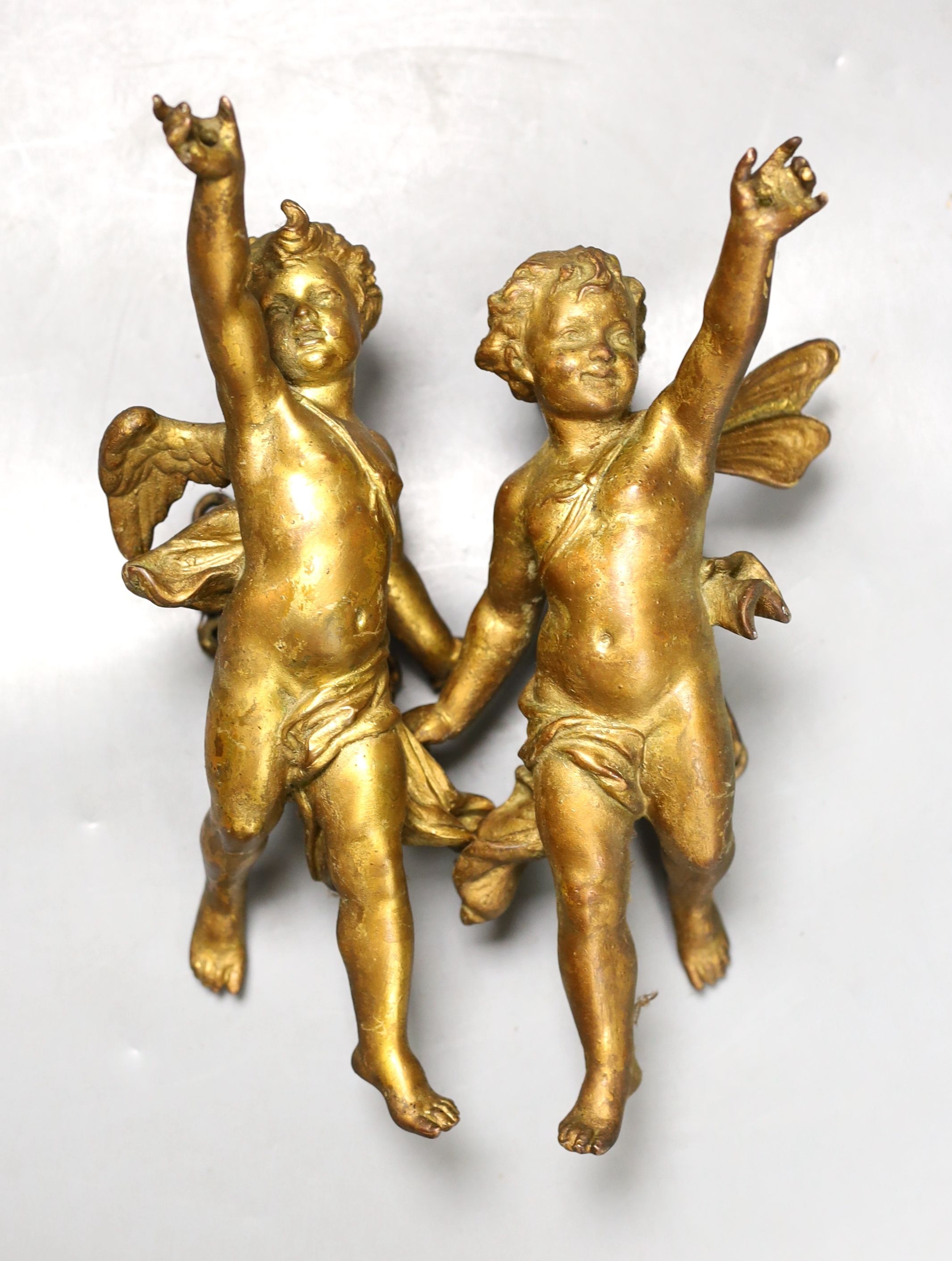 A pair of gilt metal cherub hanging figures, 26cm